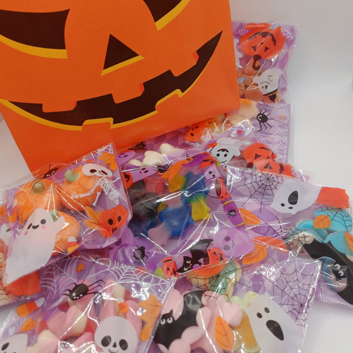 Halloween-themed goodie bags with a pumpkin design and candy packages on a white background
